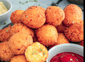 Hush puppies and a bowl of sauce, maybe ketchup.