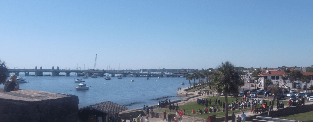 A wide scene of St. Augustine, showing the Castille de San Marcos in the background, Old Town and a stone bridge in the background. 