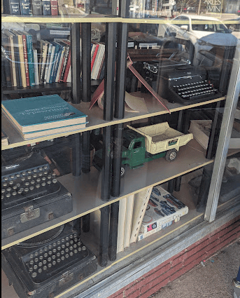 Glass cases showing typerwriters and a dumptruck toy